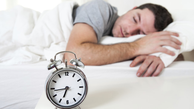 Young attractive man sleeping on bed early morning