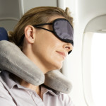 Woman sleeping on plane wearing eye mask
