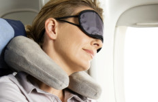 Woman sleeping on plane wearing eye mask
